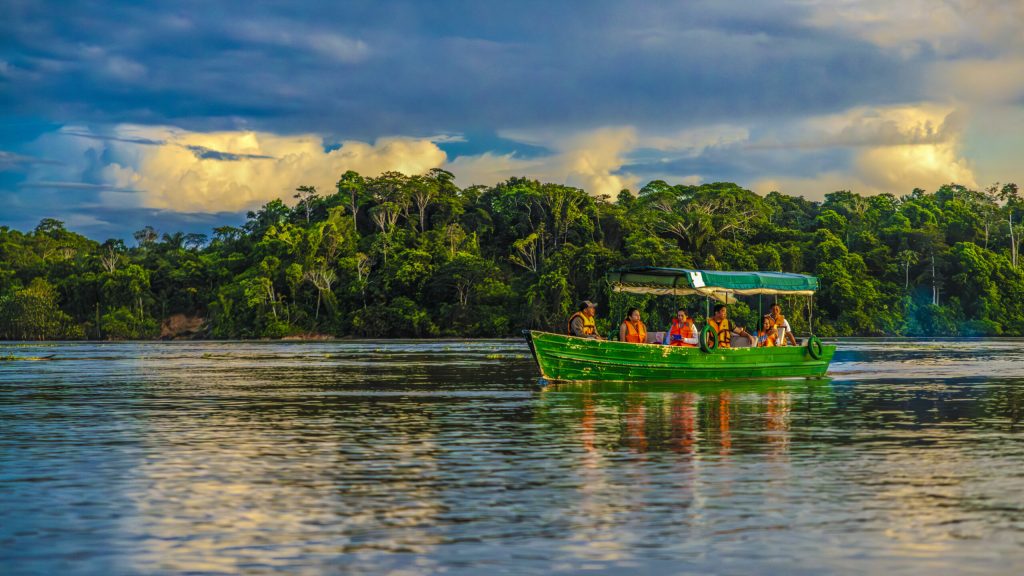 Fotografía de bote con turistas de 
amanecer en la Reserva Pacaya Samiria